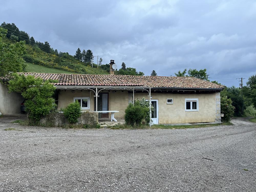 Façade de la ferme et collines en fond